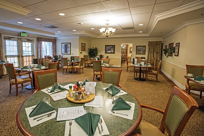 A well-arranged dining room with neatly set tables and chairs, ready for guests.