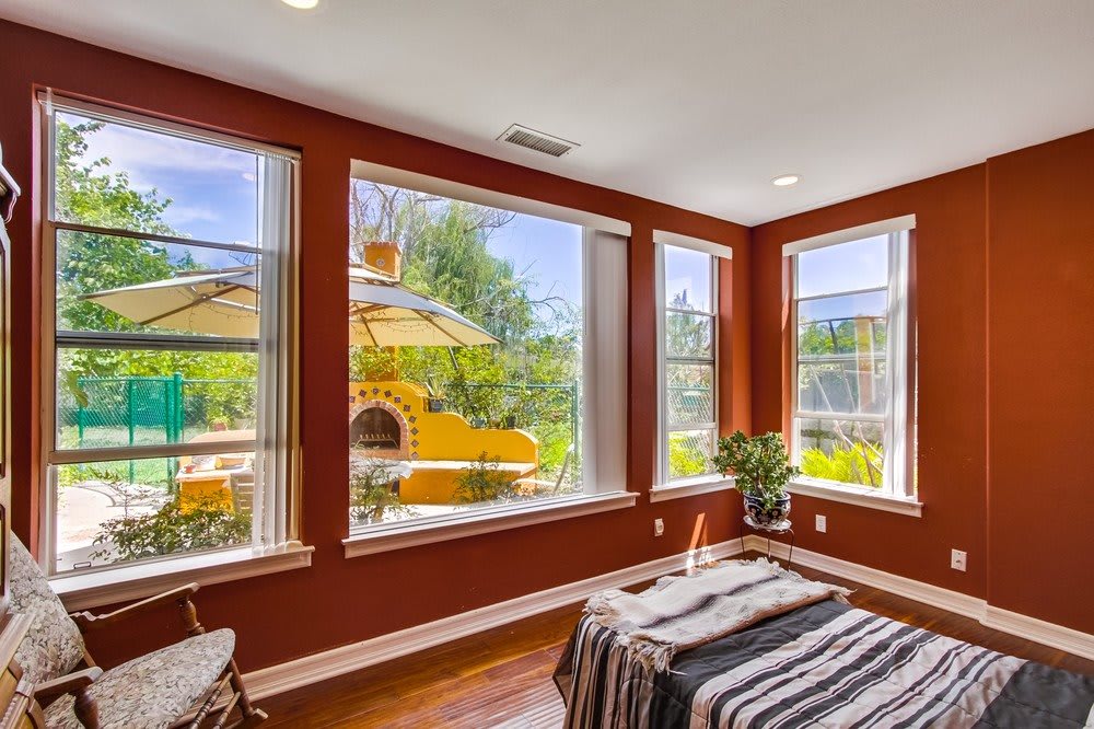 A cozy room with large windows showcasing a sunny outdoor view.