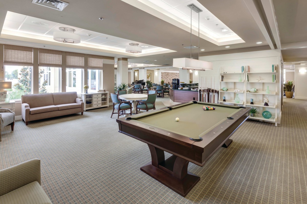 A recreation room featuring a billiards table and comfortable seating.