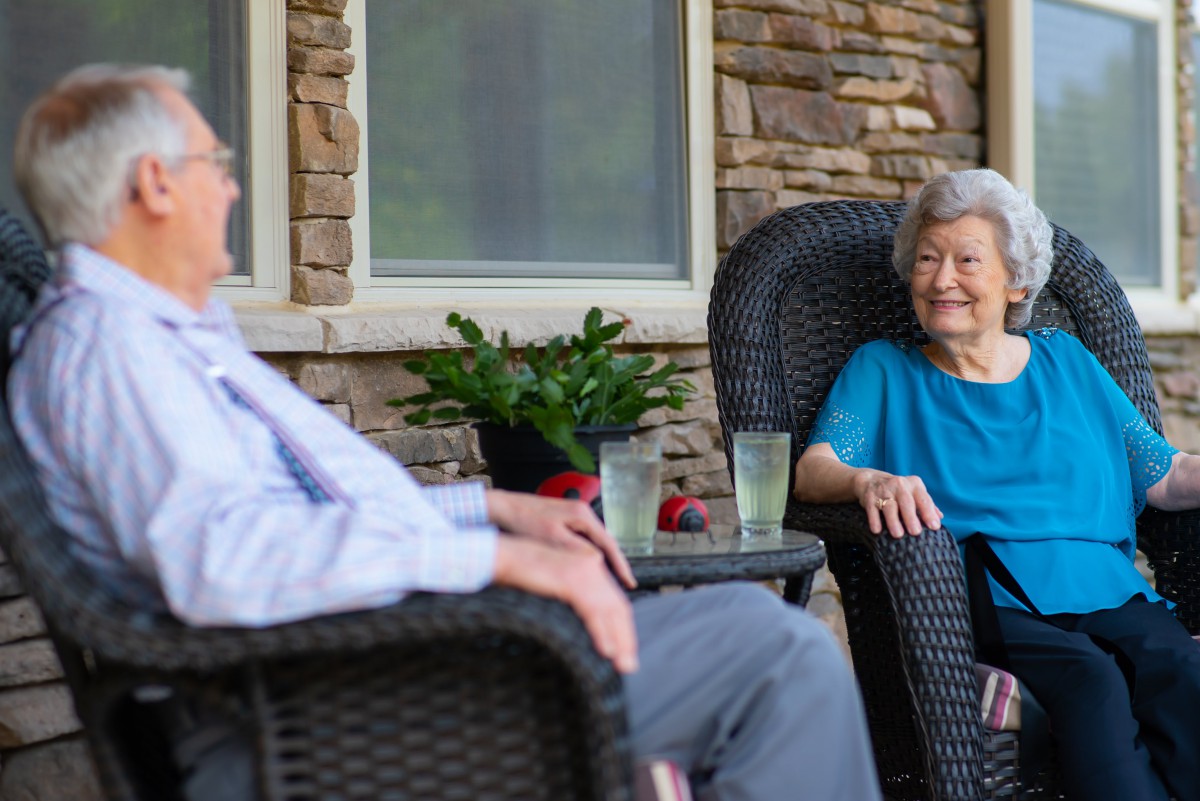 Elderly couple enjoying a relaxing afternoon on the patio.
