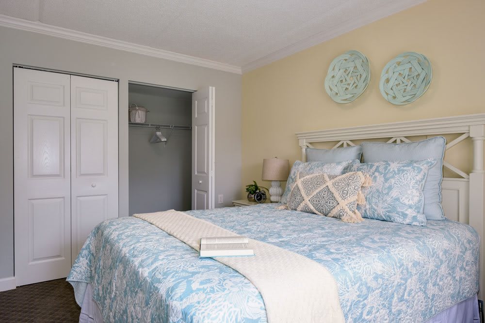 A cozy bedroom with soft, pastel decor and neatly arranged bedding.