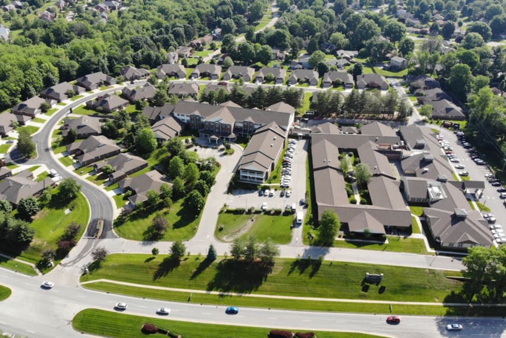 Aerial view of a suburban neighborhood with residential buildings and tree-lined streets.