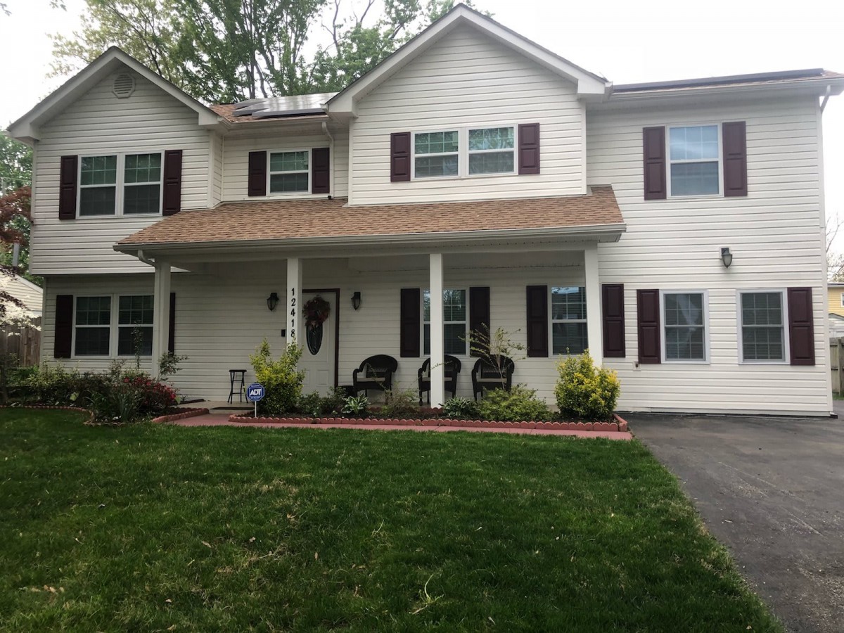 A suburban residential house with a well-maintained lawn and inviting front porch.