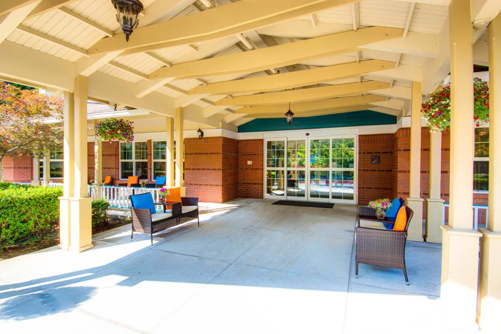A cozy outdoor seating area with colorful cushions under a covered porch.