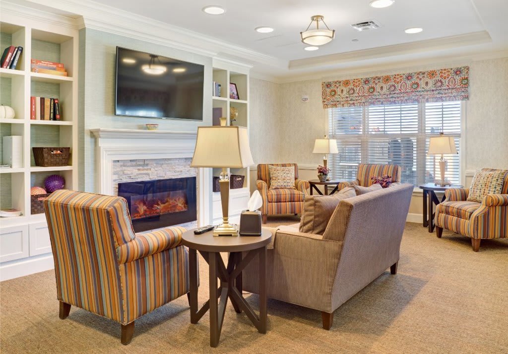 A cozy living room with comfortable seating, a fireplace, and a wall-mounted TV.