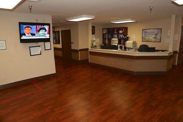 A hospital reception area with a desk and television.