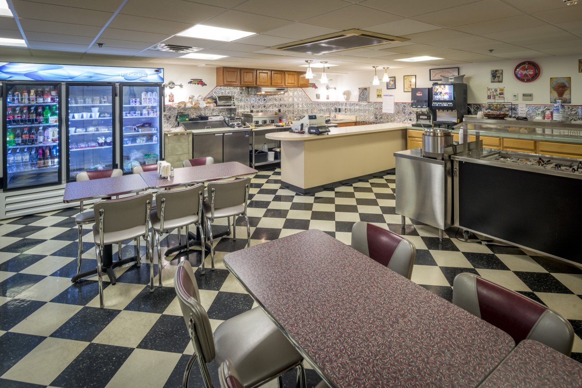 Interior view of a classic diner with checkered flooring and seating arrangements.