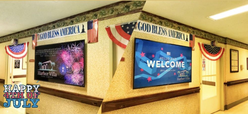 A decorated corner with American flags, patriotic signs, and digital screens displaying a welcome message.