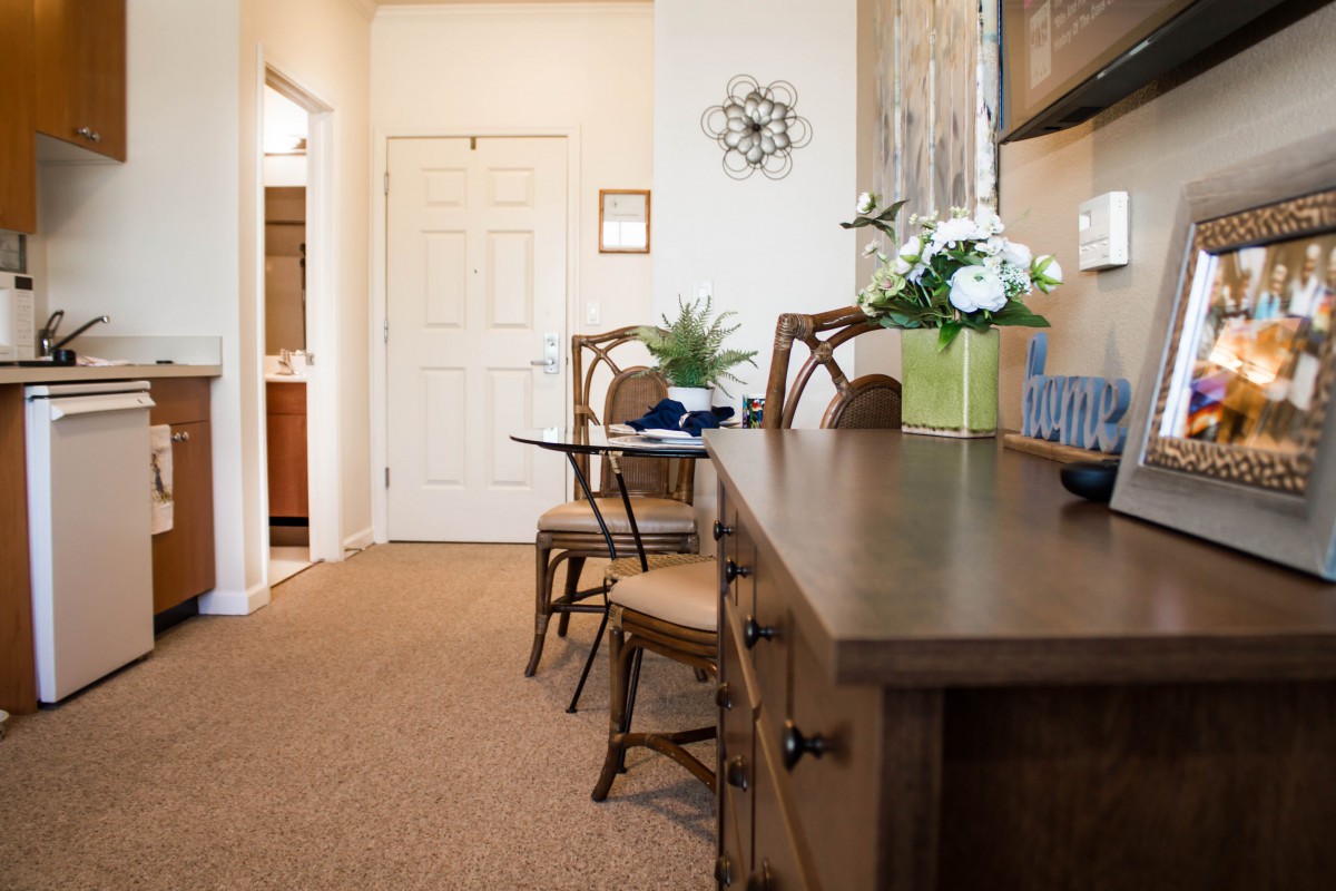 A cozy office interior with a desk and chairs, decorated with plants and artwork.