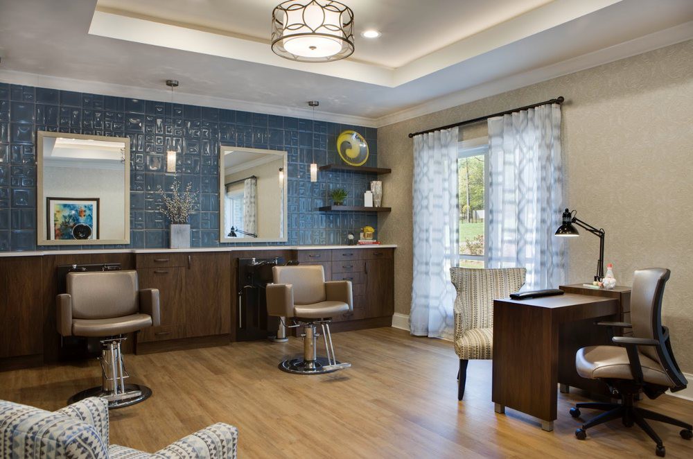 A modern salon interior with stylish chairs, large mirrors, and elegant lighting.