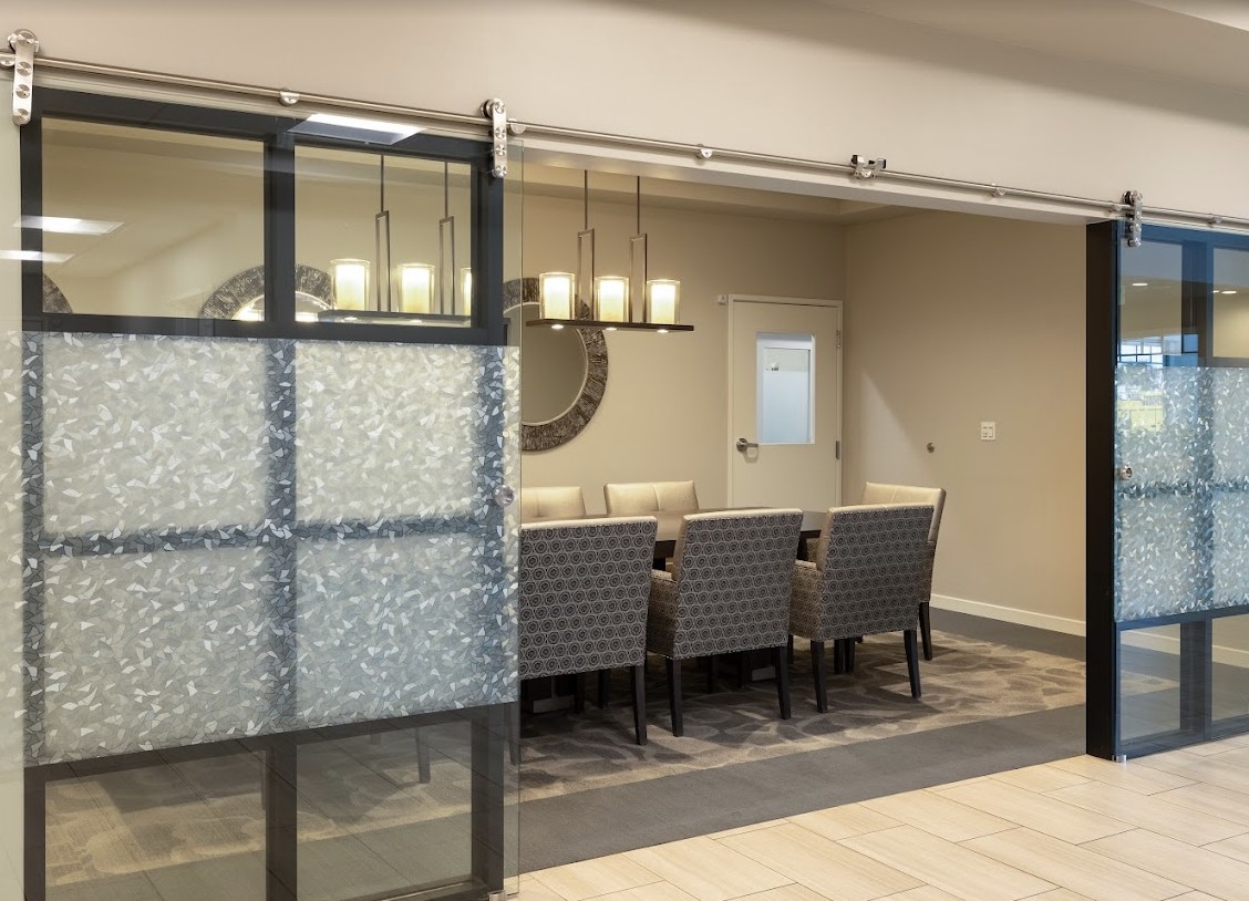 A modern dining room with a sliding glass door and elegant chandelier.