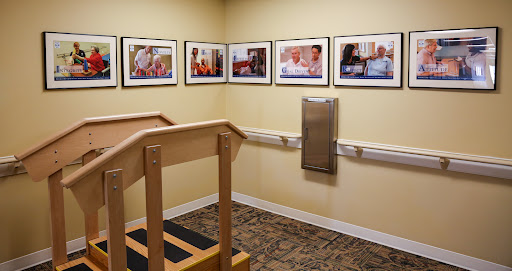 A therapy room featuring a wooden ramp and framed photographs on the wall.
