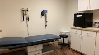 A clean and organized doctor's examination room with medical equipment.