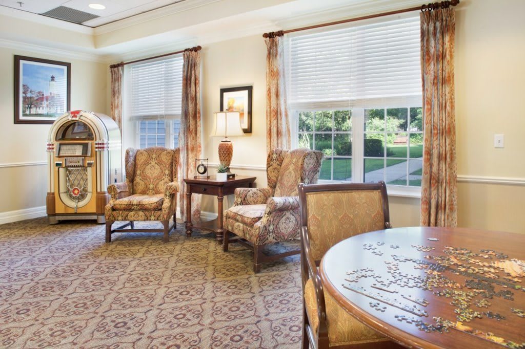 A cozy living room with comfortable seating and a jukebox.