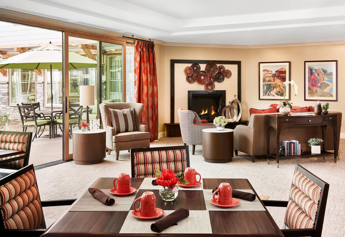 A stylish living room with red accents and a cozy fireplace.