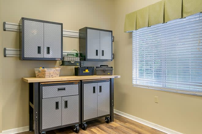 A well-organized room with storage cabinets and a workbench.