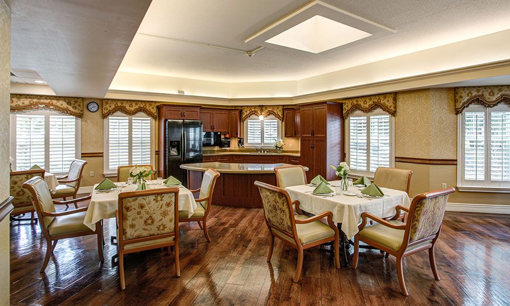 A tastefully decorated dining area with wooden furniture and an adjoining kitchen.