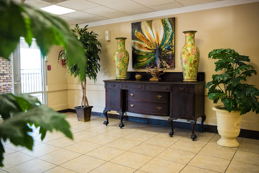 A stylish lobby featuring a wooden console table, decorative vases, and vibrant artwork.