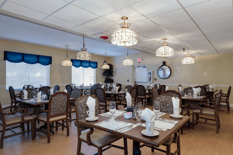 Elegant restaurant dining room with neatly arranged tables and chandeliers.