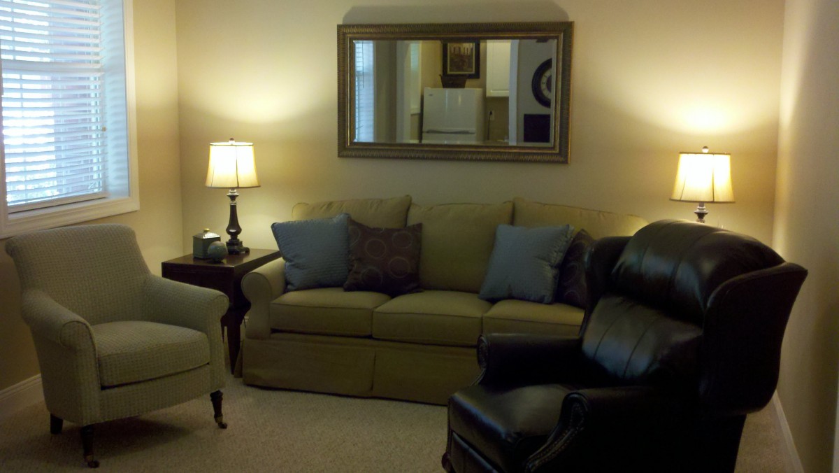 A cozy living room with a sofa, armchair, and decorative elements.