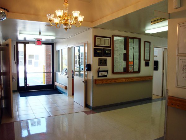A well-lit lobby with a chandelier, featuring an entrance and a reception area.