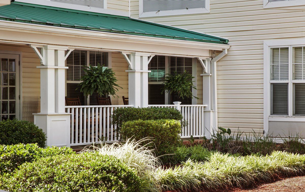 A charming house with a covered porch and lush greenery in the garden.