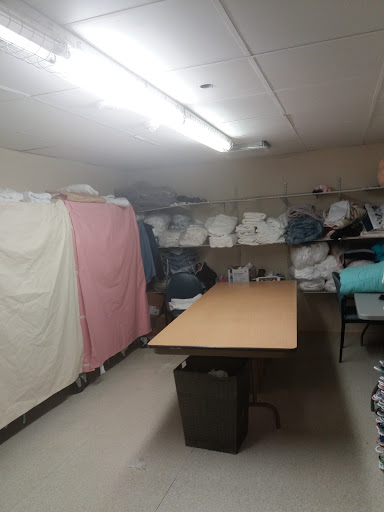 A functional laundry storage room equipped with a table and neatly stacked linens.