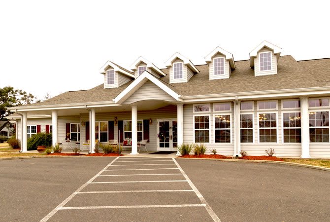 A large residential building with multiple windows and a spacious driveway.