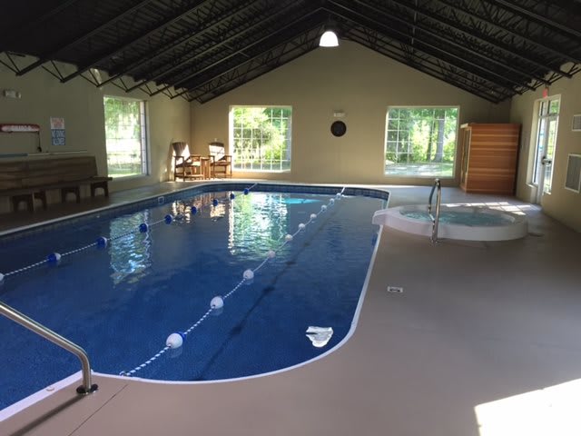Indoor swimming pool with seating area and natural light.