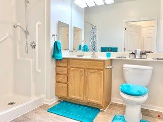 A modern bathroom with blue accents featuring a vanity and shower.