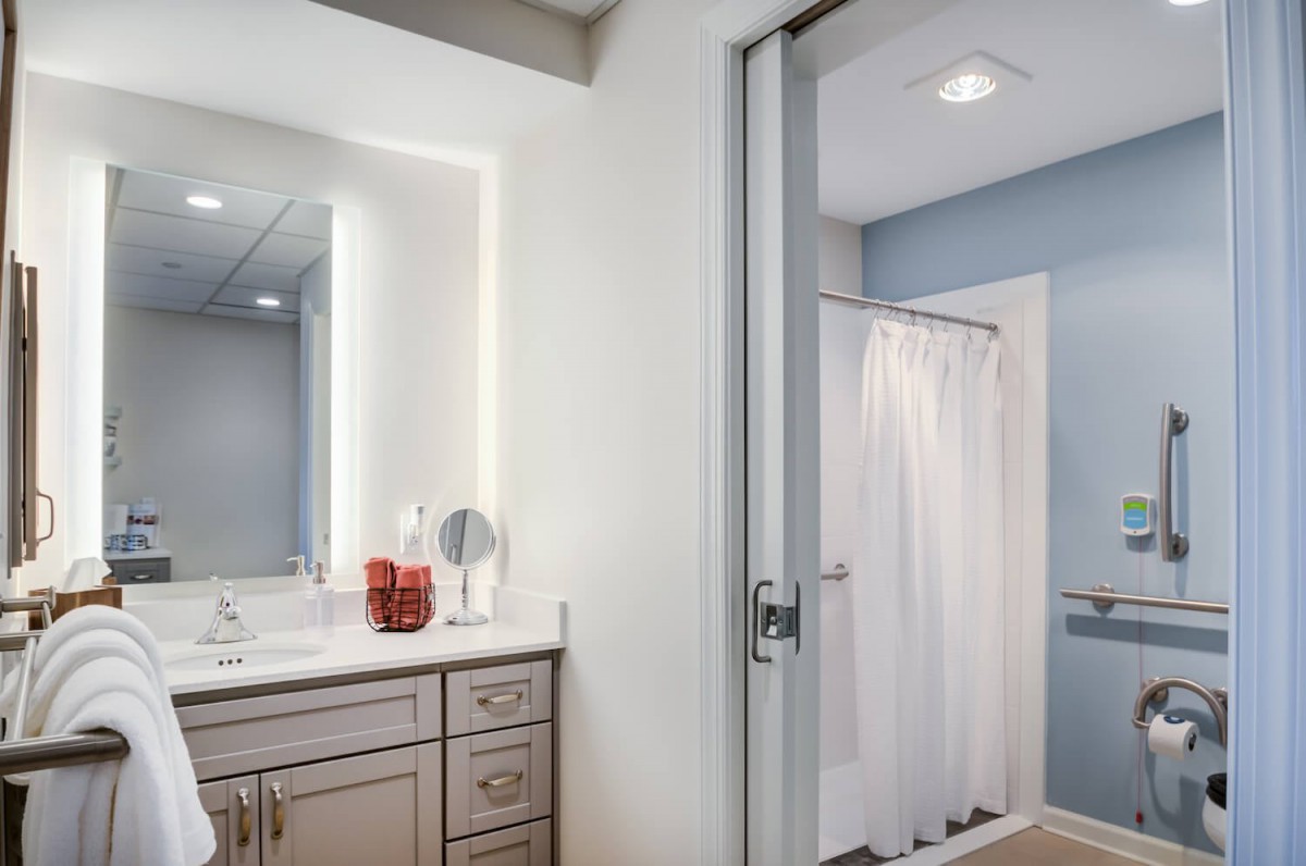 A modern bathroom featuring a vanity with a mirror and a shower area separated by a curtain.