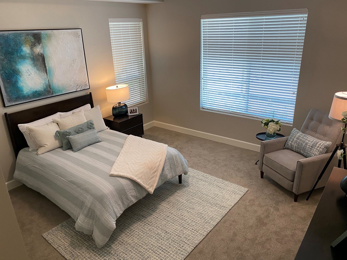 A modern and cozy bedroom with a neatly made bed, stylish decor, and soft lighting.