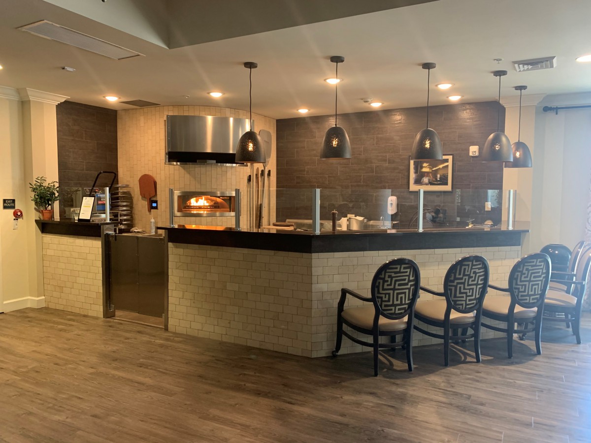 A modern restaurant interior featuring a sleek counter and seating area.