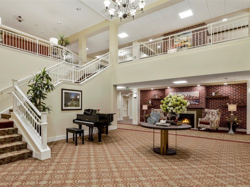 Elegant lobby with a grand staircase and piano.
