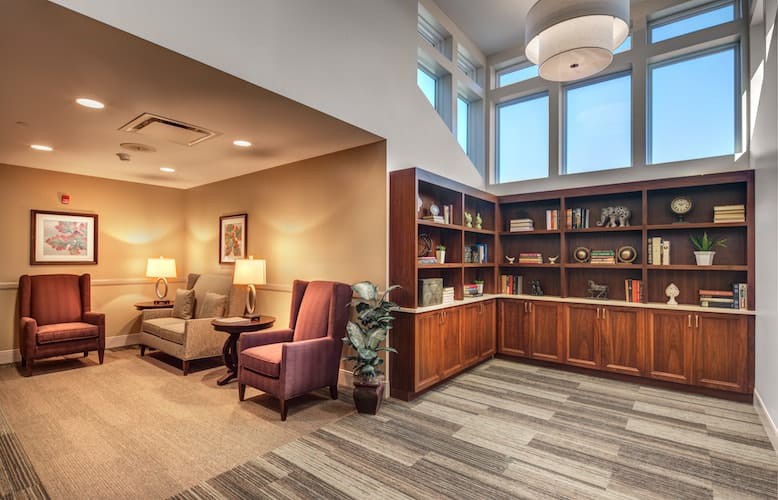 A cozy library reading area featuring comfortable seating and well-stocked bookshelves.