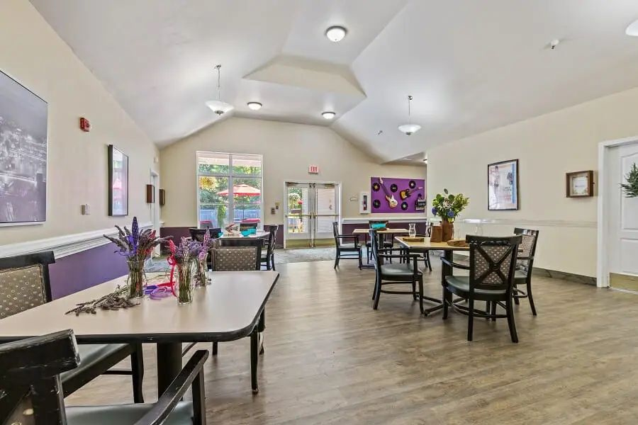 A bright and welcoming dining area with tables and chairs, featuring wood flooring and modern decor.