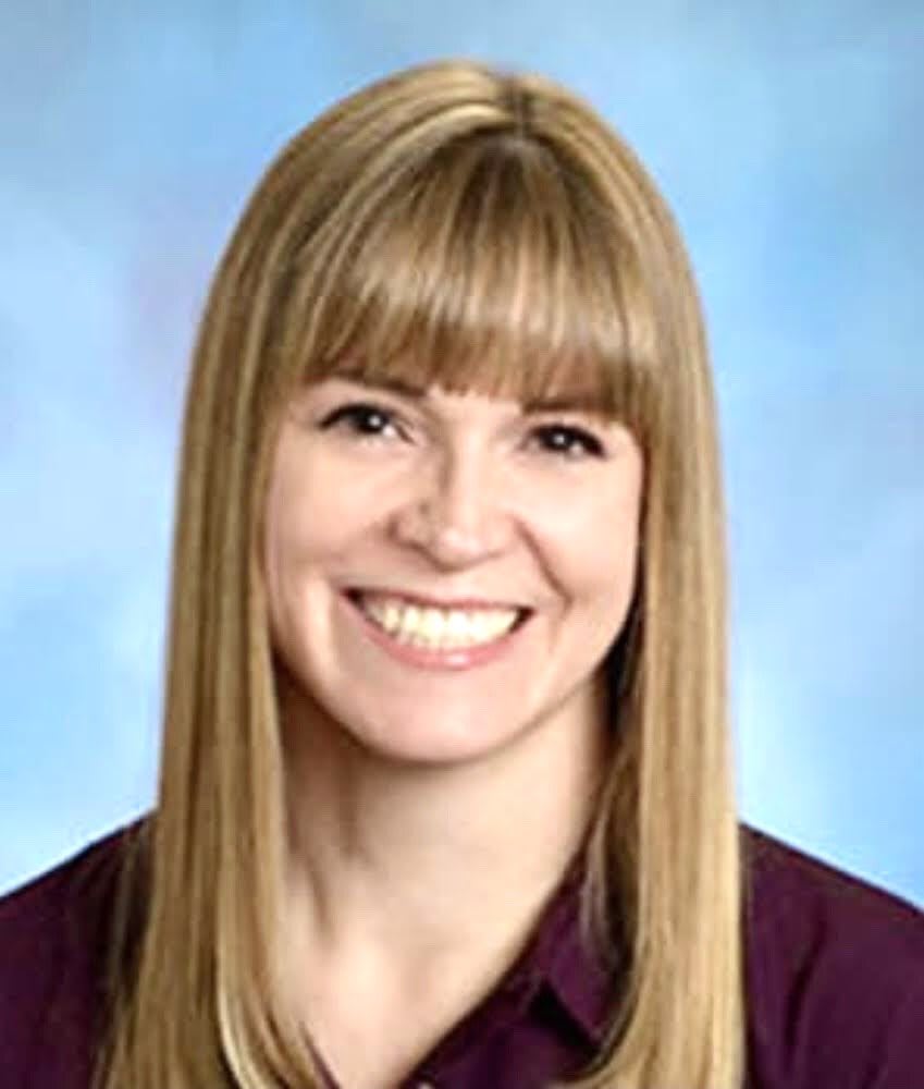 A professional portrait of a smiling woman with blonde hair.