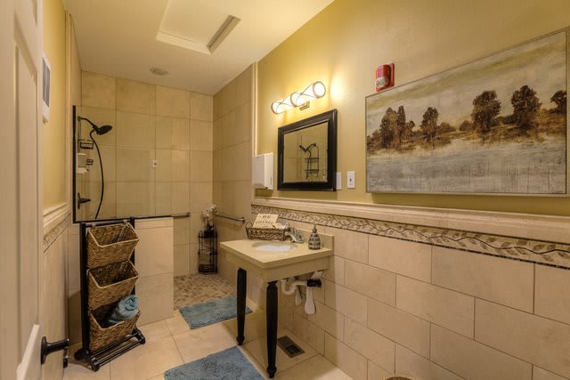 A well-designed bathroom featuring a modern sink, mirror, and tiled shower area.
