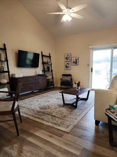 A cozy living room featuring a television, stylish shelving units, and comfortable seating.