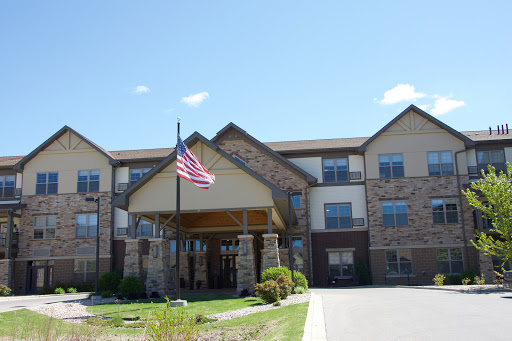 A residential building featuring an American flag in front under a clear blue sky.