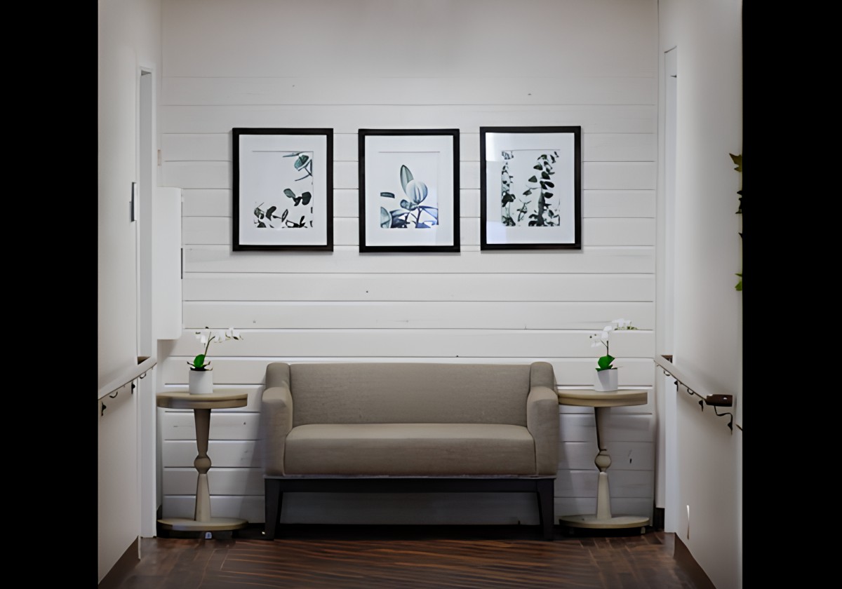 A cozy waiting area with a sofa and framed artwork on the wall.