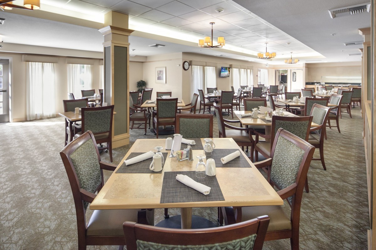 A spacious dining area with neatly arranged tables and chairs, ready for guests.