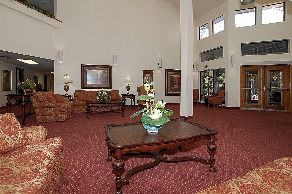 A spacious hotel lobby with elegant furniture, featuring a seating area and decorative elements.