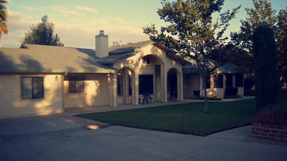 A suburban house with a well-maintained lawn and driveway.