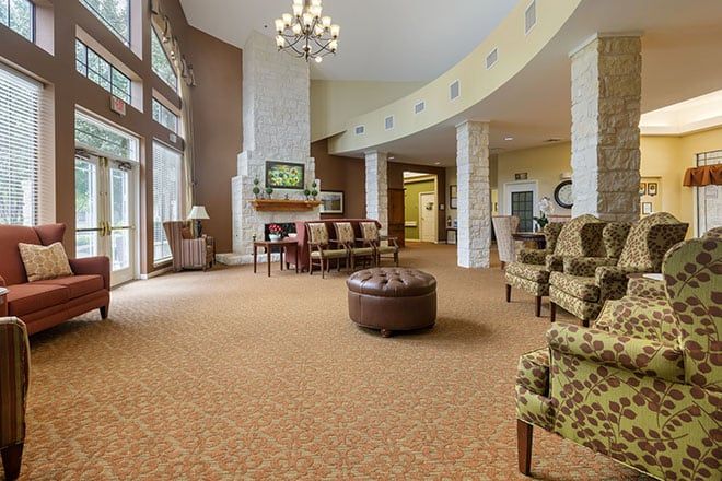 A spacious and elegantly designed lobby with comfortable seating, large windows, and a chandelier.