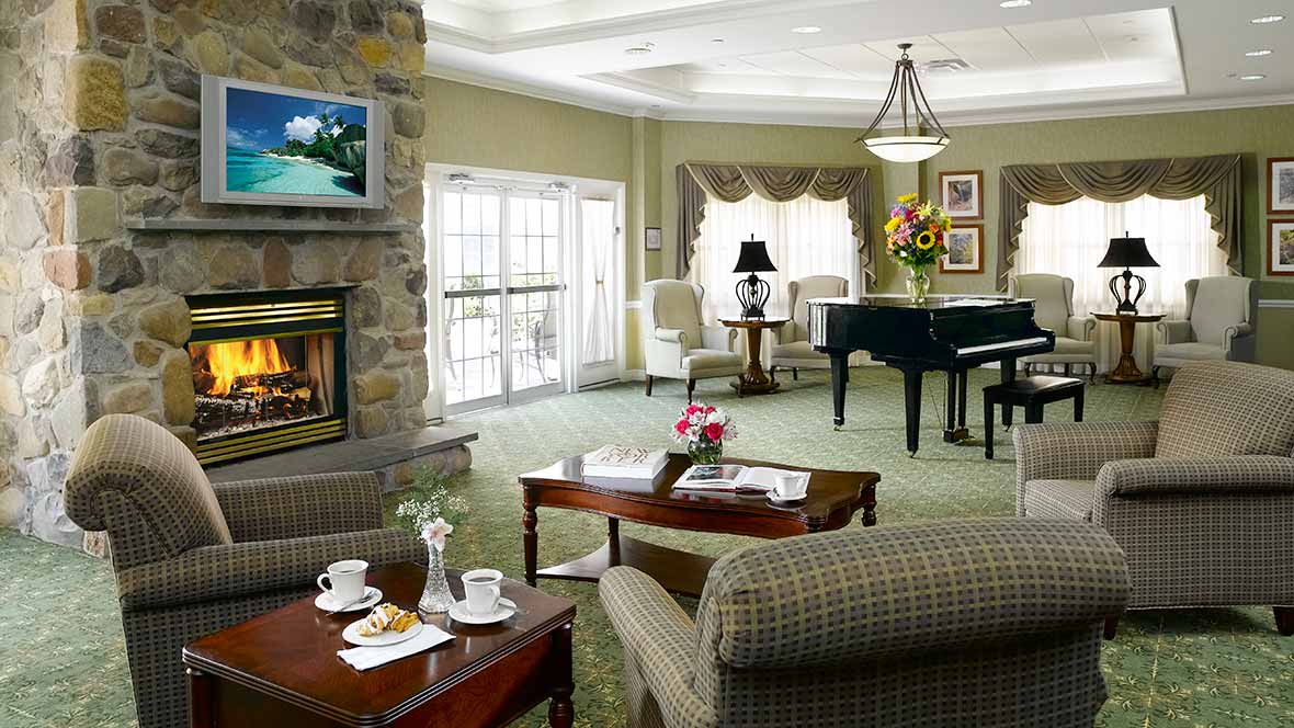 A cozy living room featuring a piano, fireplace, and elegant furnishings.