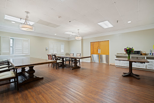 A spacious dining area featuring elegant wooden furniture and ample natural light.