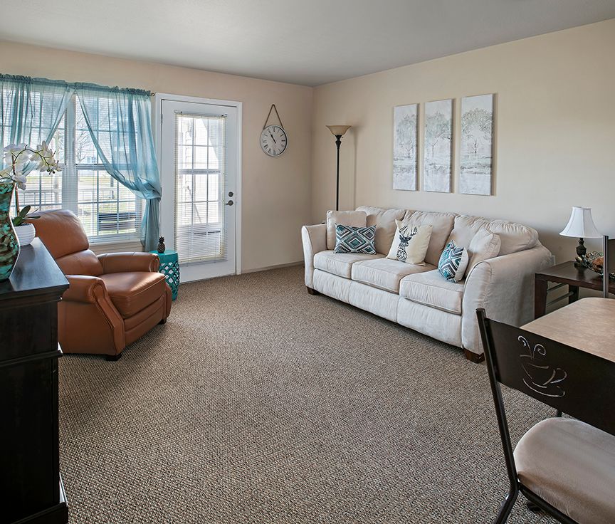 A cozy living room with a sofa, armchair, and decorative elements.