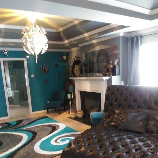 A stylish living room with modern decor, featuring a unique chandelier and a decorative rug.