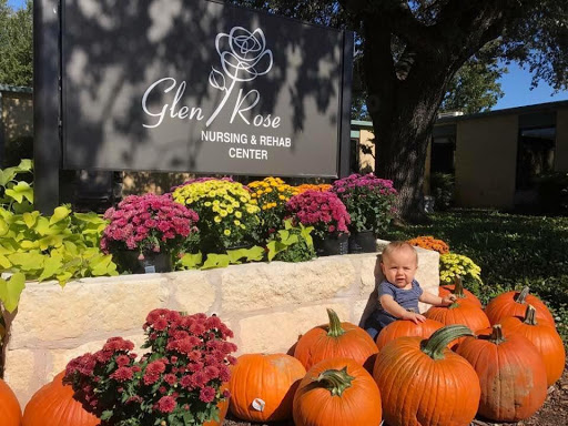 A joyful moment surrounded by pumpkins and vibrant flowers at Glen Rose Nursing & Rehab Center.